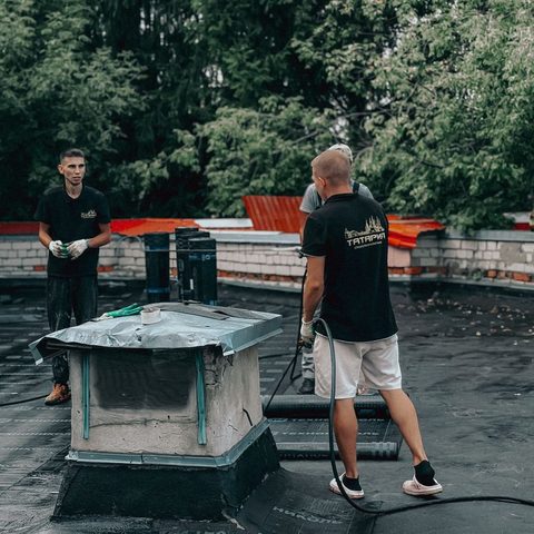 Équipe au travail sur un toit plat, chantier d’Altitudes Toiture