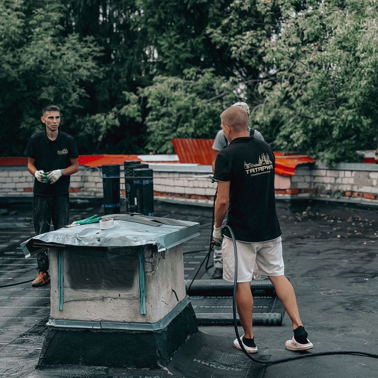 Équipe au travail sur un toit plat, chantier d’Altitudes Toiture