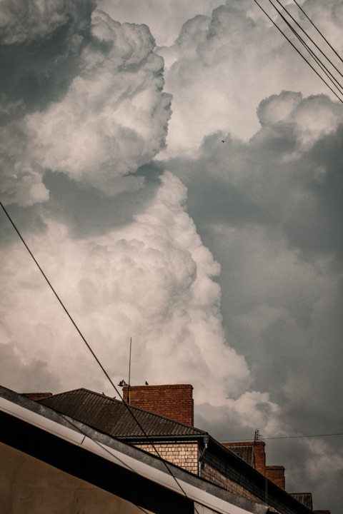 Ciel d'orage sombre sur des toits mitoyens, urgence toiture à Liège