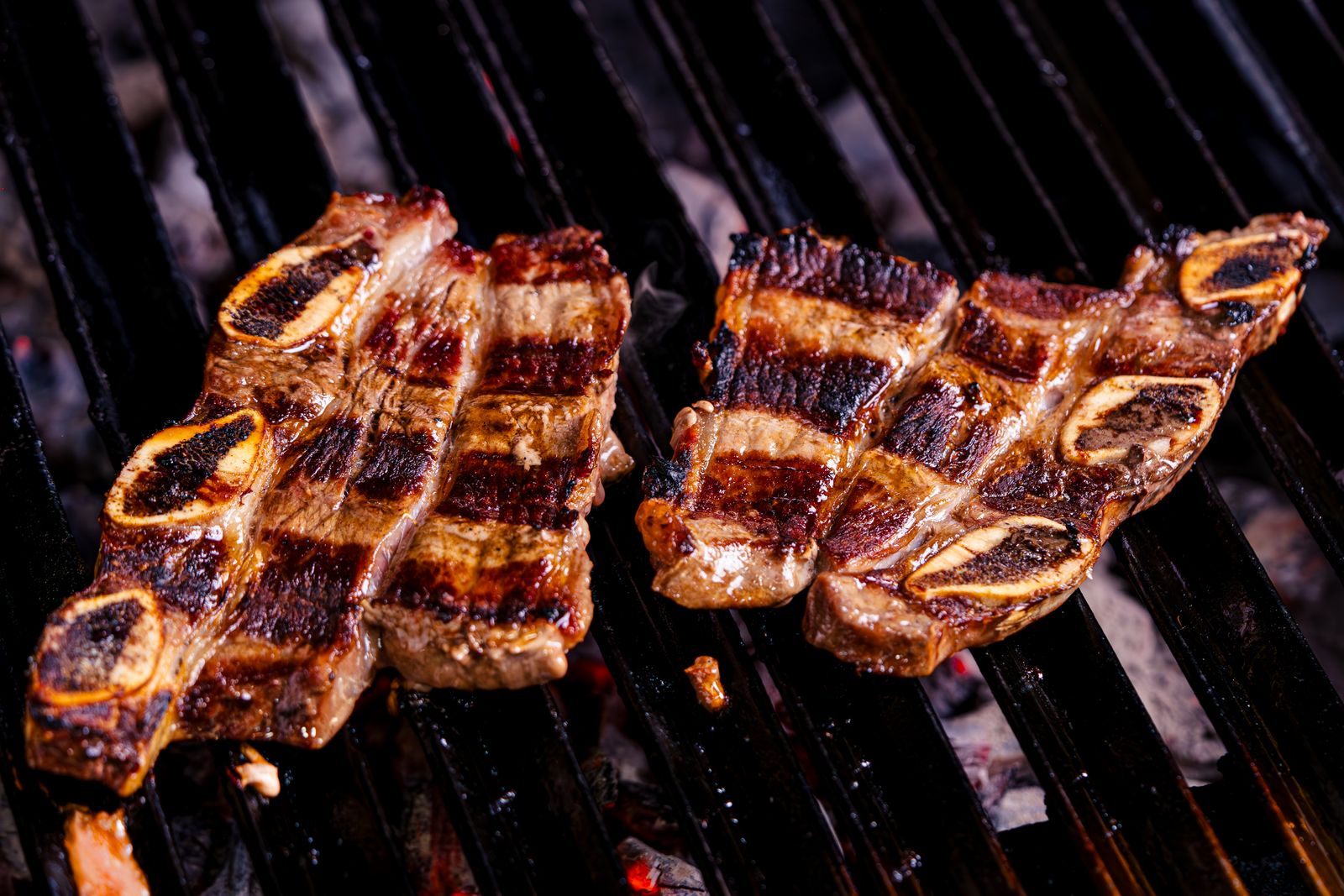 Photo d’illustration — travers de bœuf laqués, caramélisés, gros plan, fond sombre